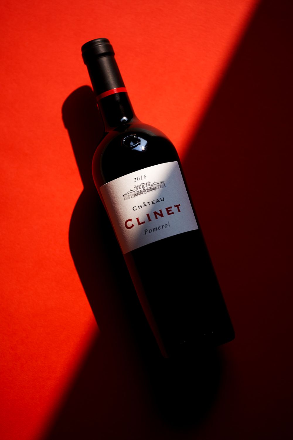 The Clinet bottle on a contrasting background split into two parts, red and black.